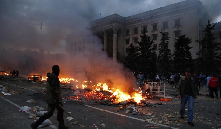 A protester walks past a burning pro-Russian tent camp near the trade union building in Odessa