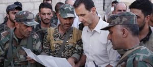 In this photo released on Sunday, June 26, 2016, by the Syrian official news agency SANA, Syrian President Bashar Assad, second right, speaks with Syrian troops during his visit to the front line in the Damascus suburb of Marj al-Sultan, Syria. (SANA via AP)